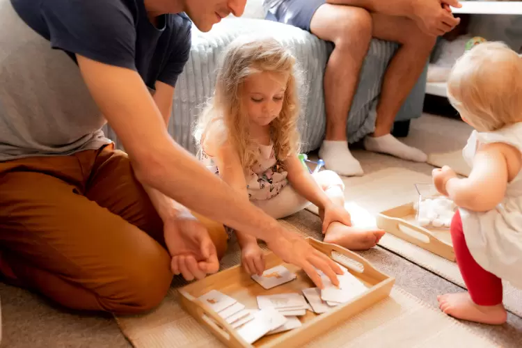 Photo d'un papa qui joue avec sa fille avec des cartes de nomenclature Montessori