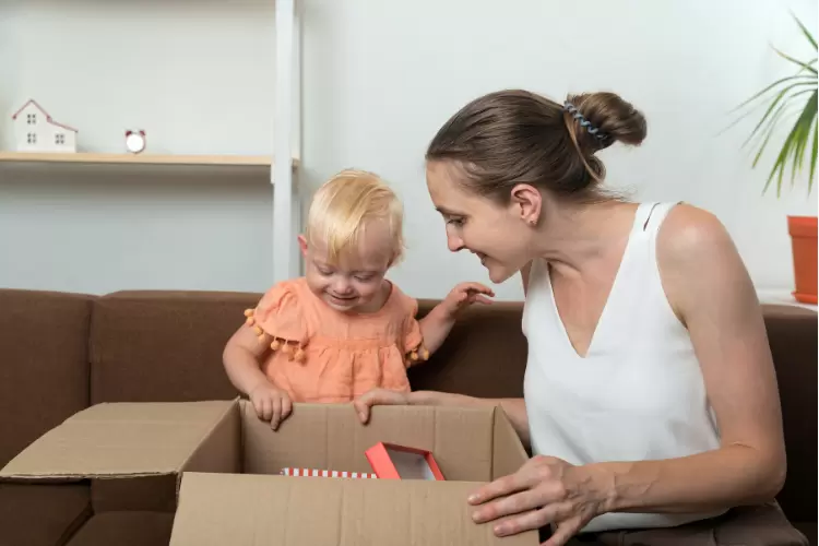 Photo d'une maman qui joue avec son enfant et une boite de jouets